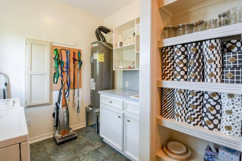The laundry room is located next to the pantry and contains a sink and the water heater for easy access.