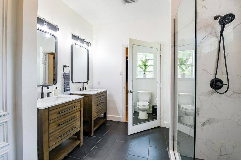 Stunning matching vanities in the primary bathroom along with matching mirrors and vanity lights.