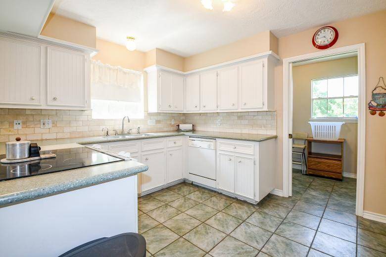 The kitchen was recently remodeled with solid counters and a timeless tile backsplash.