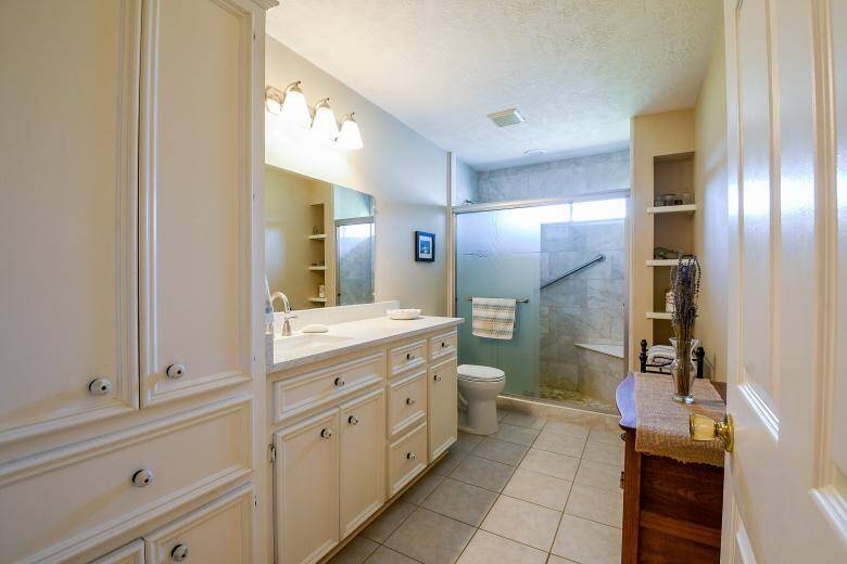 The newly renovated bathroom in the second home has an accessible shower with sliding glass doors, the vanity has gorgeous solid stone counters.