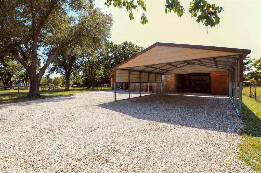 The second residence had a recently installed carport that stands above the newly laid river rock gravel driveway.