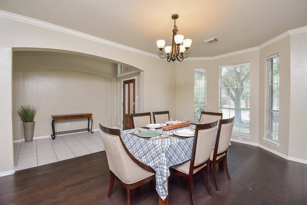 Bright dining area with a large window and modern chandelier making this space a perfect spot for evening meals.