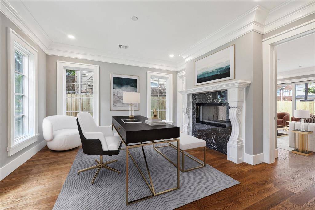 The lovely large formal living room/study/music room is located right off the front foyer and features a double sided fireplace with black marble surround and custom mantle! Glass doors on both sides can be closed for additional quiet or privacy. This photo has been virtually staged.