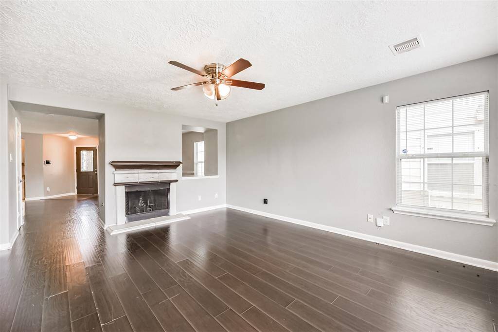 Spacious family room with abundant natural light and a cozy fireplace, perfect for gatherings.