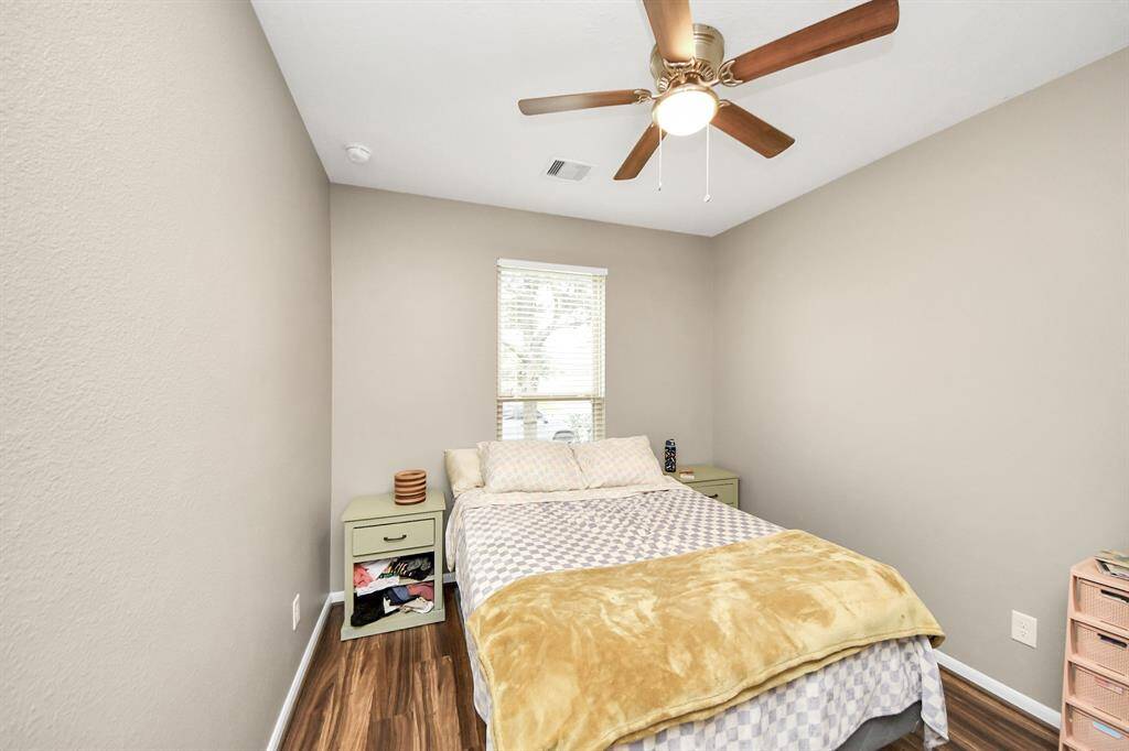 Second bedroom features aceiling fan and a largewindow.