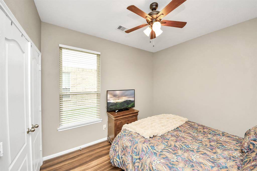 Third bedroom features aceiling fan and a largewindow.