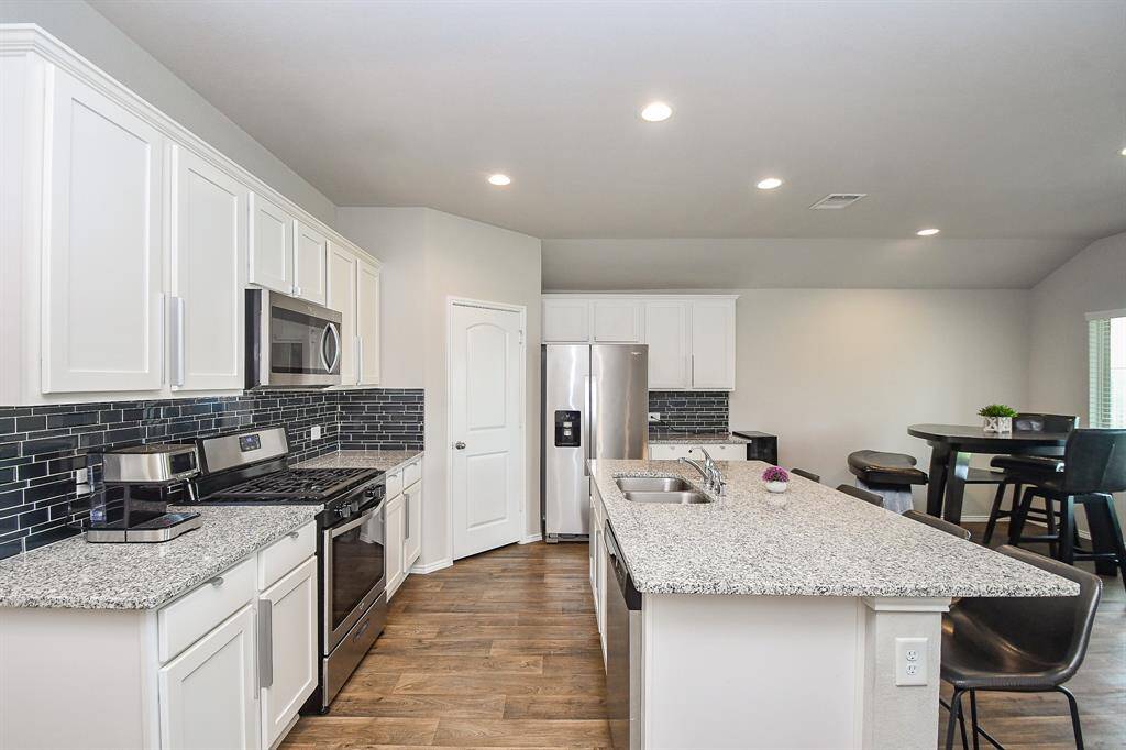 This chef's kitchen is a family cook's dream! Wide open paths, granite counters everywhere you step (with rich, deep colored tile backsplash); shining stainless steel appliances, and extended island (housing stainless steel sinks) and tremendous cabinetry, up and down, caters to every task!