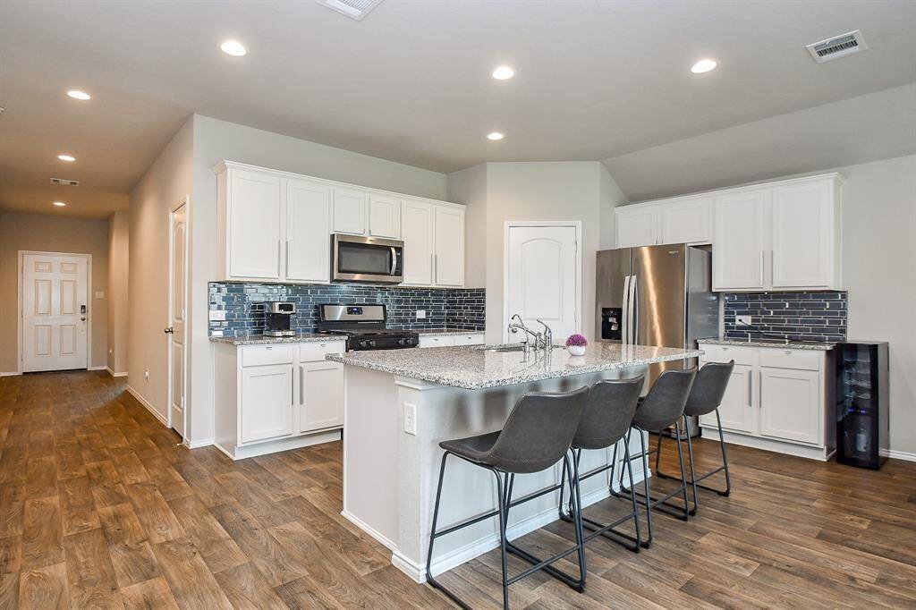What a fresh, open view from kitchen (and stools under the long extended counter!), all the way down to the front door, left!