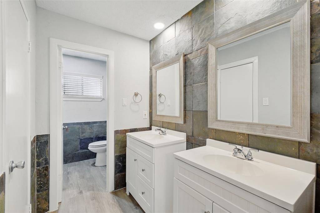 The primary bath has been recently updated with dual vanities, framed mirrors and updated lighting.