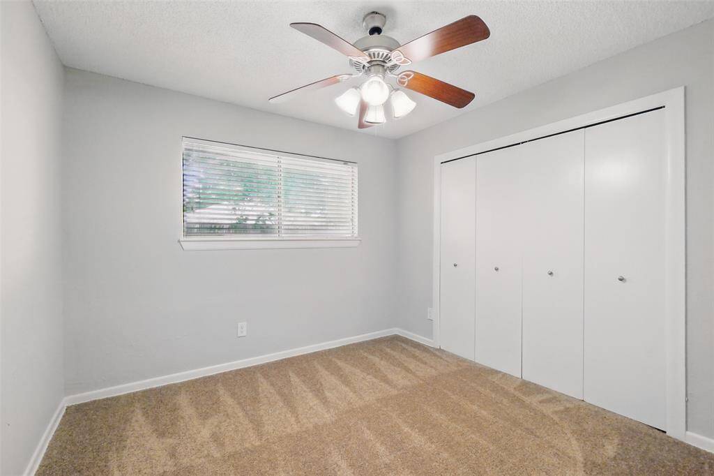 Bedroom #2 with a ceiling fan and large closet.