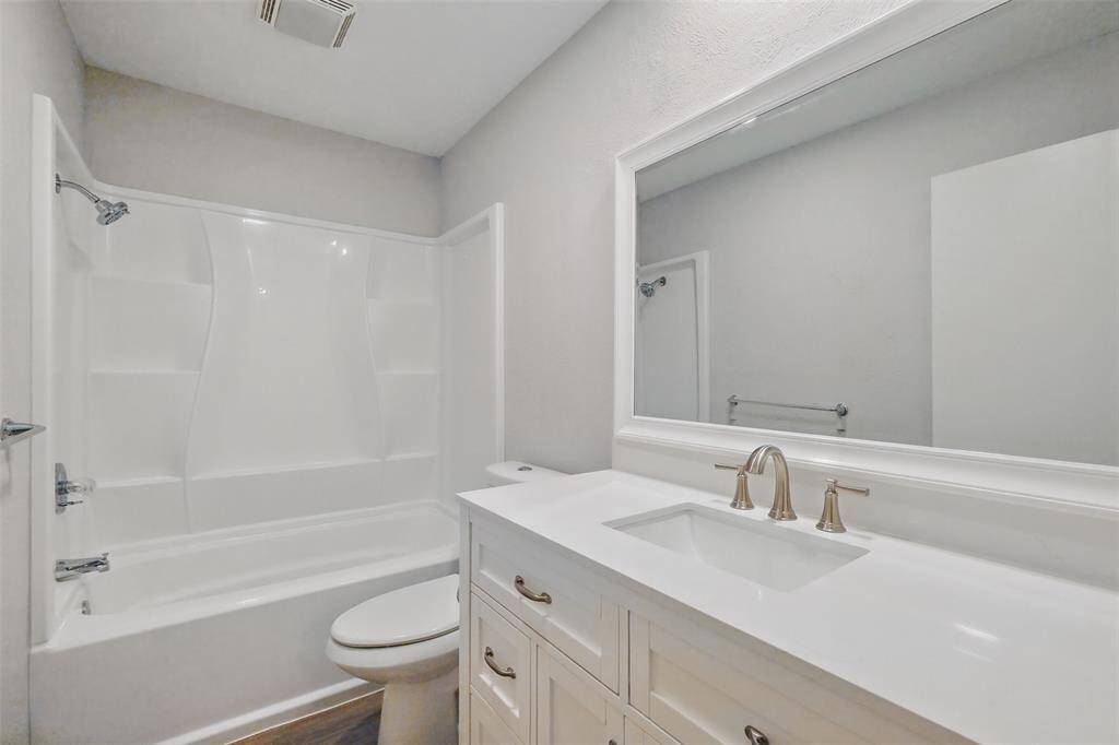 Renovated 2nd bath with with crisp white cabinetry with attractive hardware, updated fixatures and a framed mirror. Extra built-in storage in the hall.