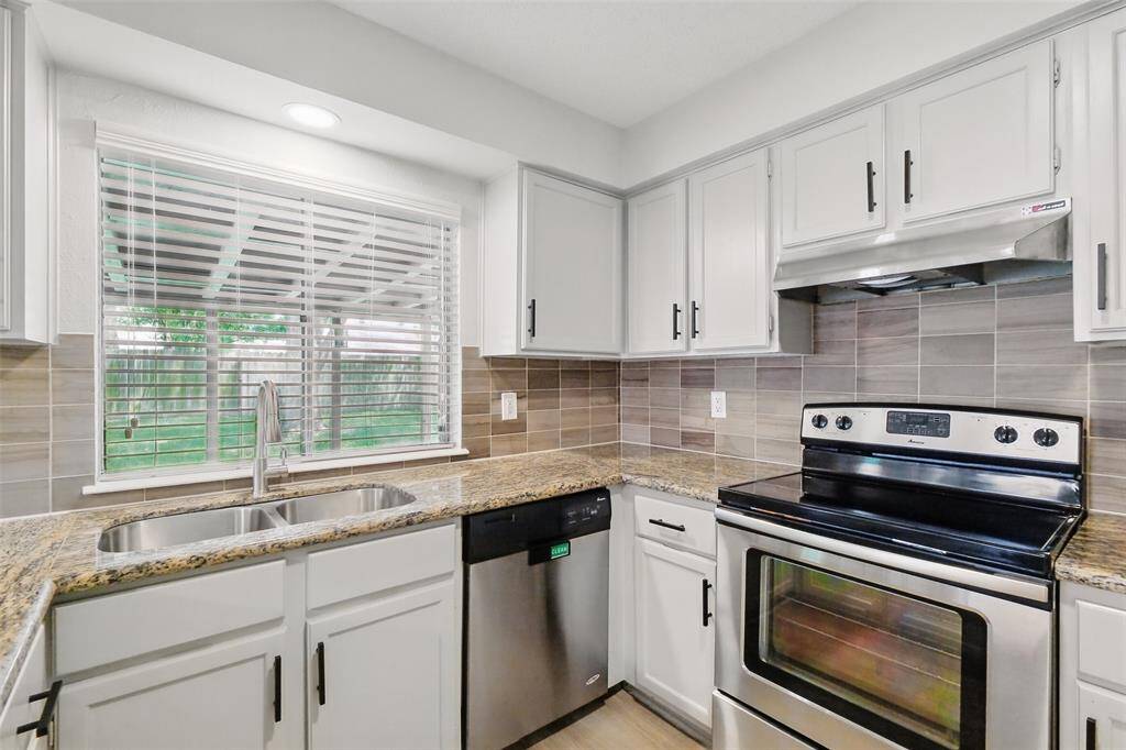 The large window above the undermount sink provides ample natural light and a view of the backyard.  Stainless steel dishwasher and range.