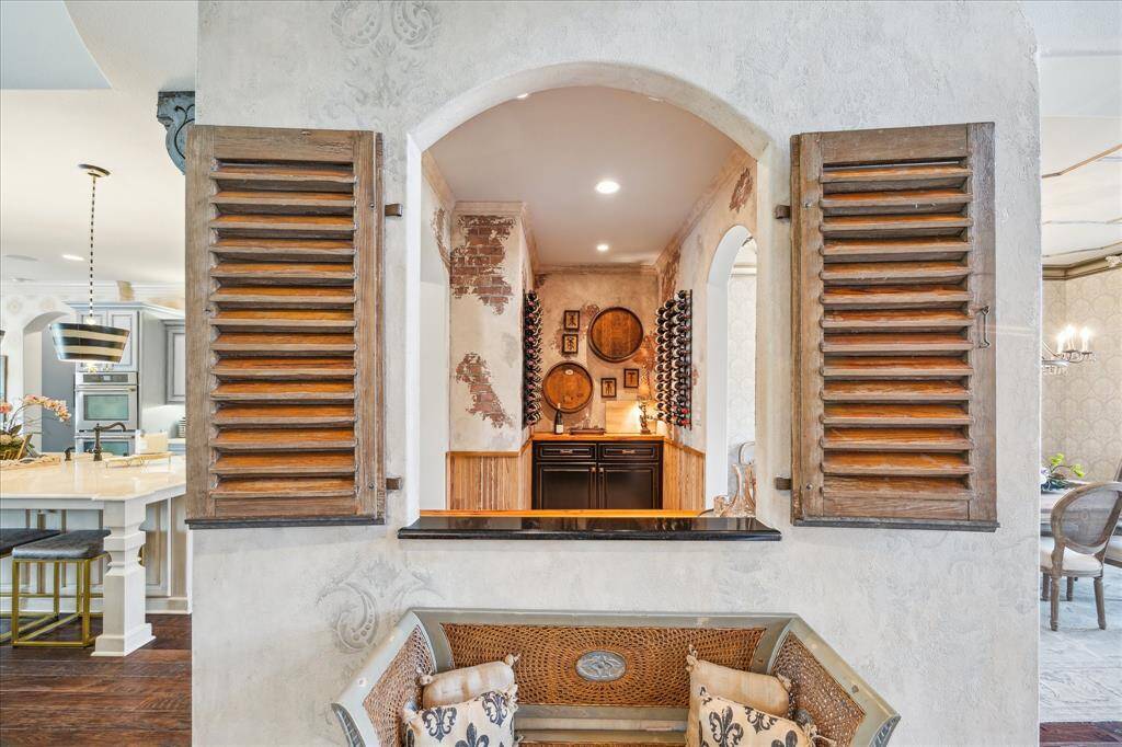 The formal entry features an interior serving niche showcased with antique French shutters allowing for effortless entertaining in this open floorplan.