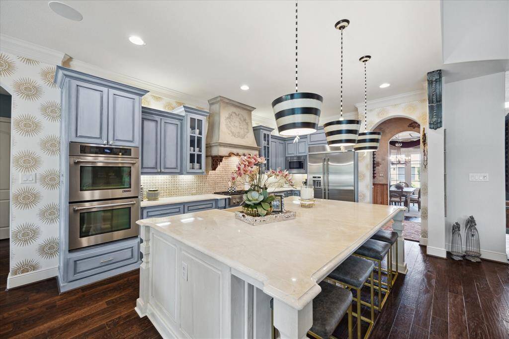 A custom designed and crafted vent hood elevates the aesthetics of this culinary space. The kitchen boasts state of the art stainless steel appliances including a double oven, 6 burner gas cooktop, built in refrigerator, dishwasher and microwave.