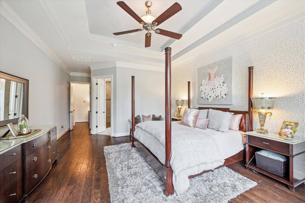 Handsome wood flooring provides warmth to the primary suite which otherwise portrays a soft cool designer aesthetic.