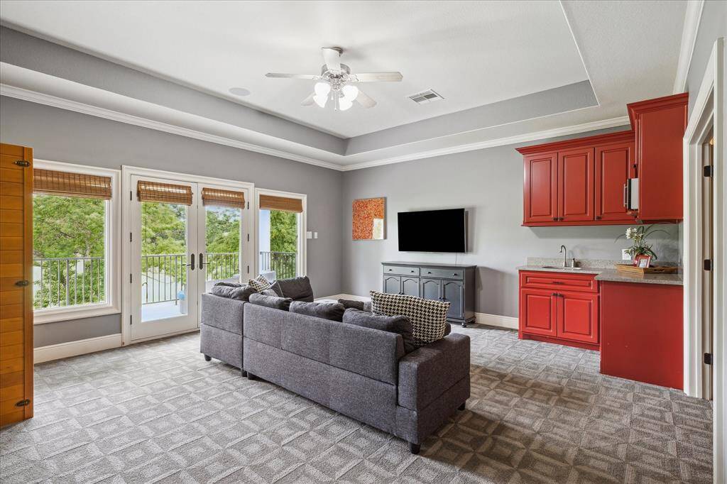 The generously sized game room provides a magnificent view of the golf course through a wall of windows and French doors accessing the covered balcony. This room could easily accommodate a billiard or ping pong table with plenty of space remaining for lounging as well.