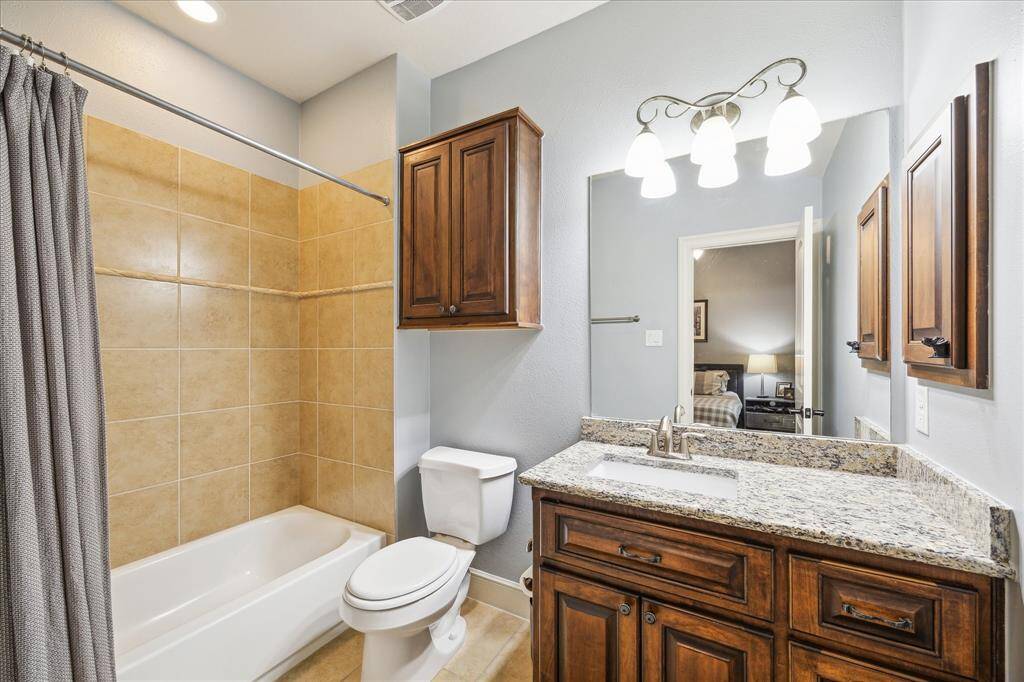 A large en-suite bath with substantial countertop space and storage cabinetry.