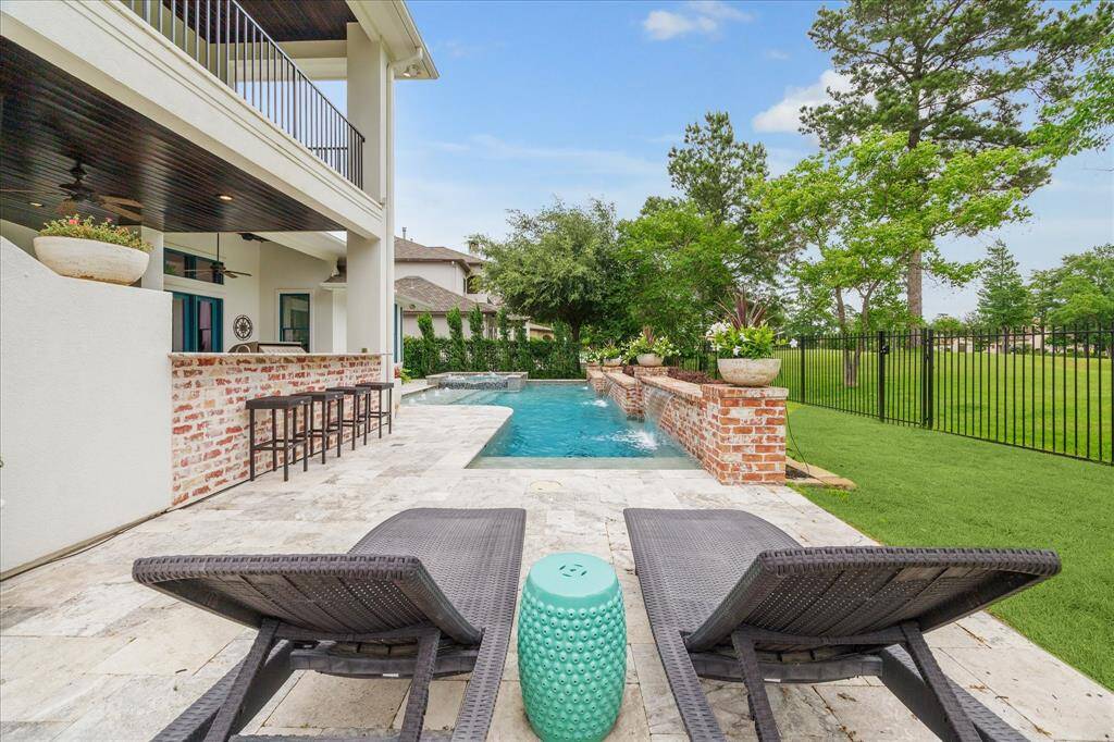 The expansive bar of the summer kitchen seats over six. This lounge area is the perfect location with a view of the house, pool and golf course!