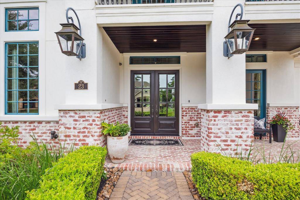 The two-story Chicago Brick front porch and balcony with custom wrought iron railing is reminiscent of New Orleans-style architecture. Bevolo copper gas lanterns across the veranda cast a warm and inviting glow.