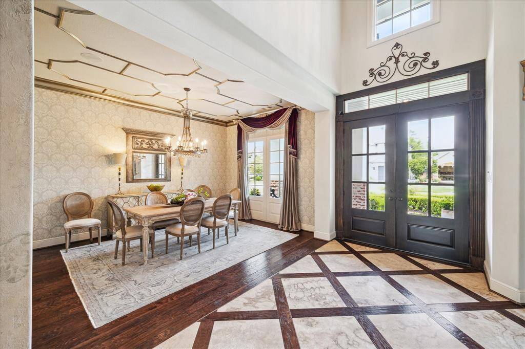 The formal dining room can accommodate even the largest of dinner parties and holiday meals. Lovely wallpaper, accented with geometric wainscoting on the ceiling and intricate crown molding, gives the room a rich and festive atmosphere.