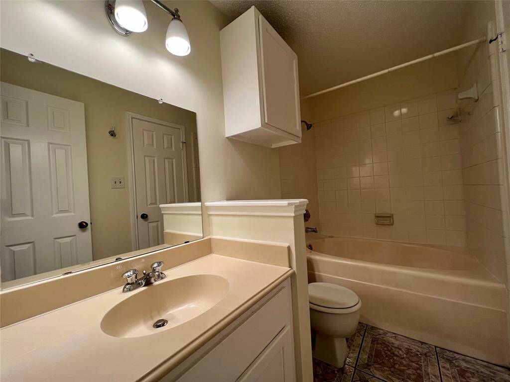 Bedroom 1 en suite bath with whirlpool, garden-style shower/tub and updated cabinetry and fixtures.