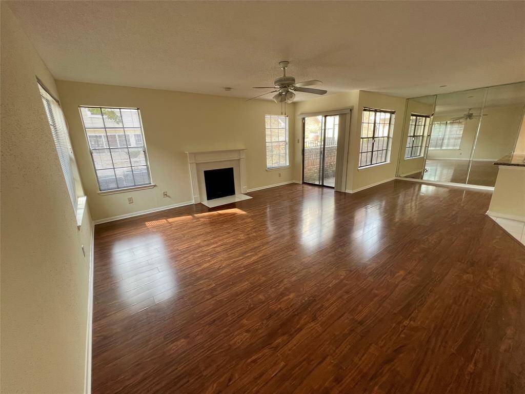 View upon entry with nice, laminate flooring throughout. Light and bright living room with plenty of windows. The fireplace adds warmth to the space.