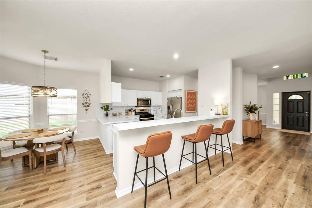 The kitchen includes a long island with space for high bar stools, creating a casual spot to eat, work, or chat—perfectly positioned between the kitchen and living room for easy flow.