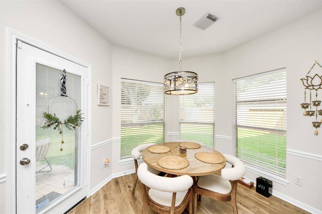 A beautiful wall of windows fills the breakfast area with natural light, creating a bright and cheerful space. The elegant chandelier adds a subtle touch of class, making this cozy nook the perfect place for casual meals—right off the kitchen for easy access.