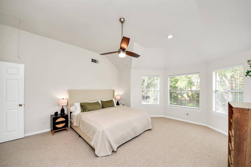 The primary bedroom boasts high ceilings and an open layout that offers plenty of space to display your favorite furniture and decor without sacrificing comfort or function. This generous room invites you to create a personalized retreat—whether that’s a cozy reading corner by the windows or an elegant arrangement that enhances its warm, inviting ambiance.