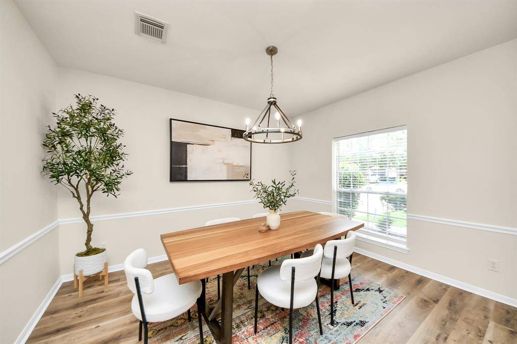Another view of the formal dining room showcases its modern, open layout and warm, inviting atmosphere. Bathed in natural light, it’s the perfect space to gather and enjoy.