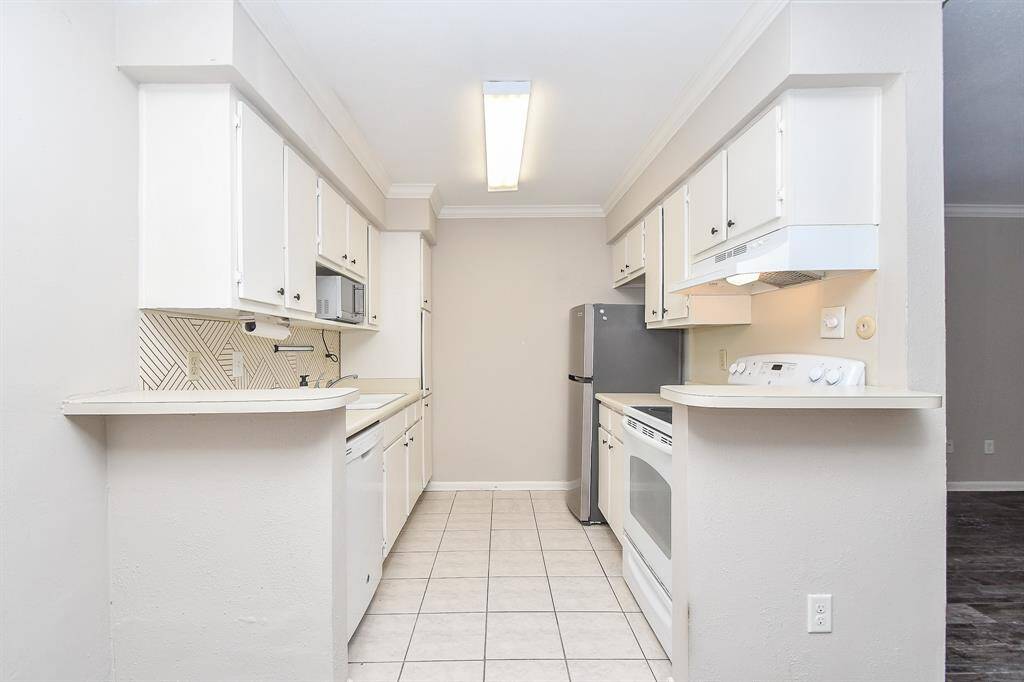 Charming kitchen with white tile floors and a luminous drop-in light!
