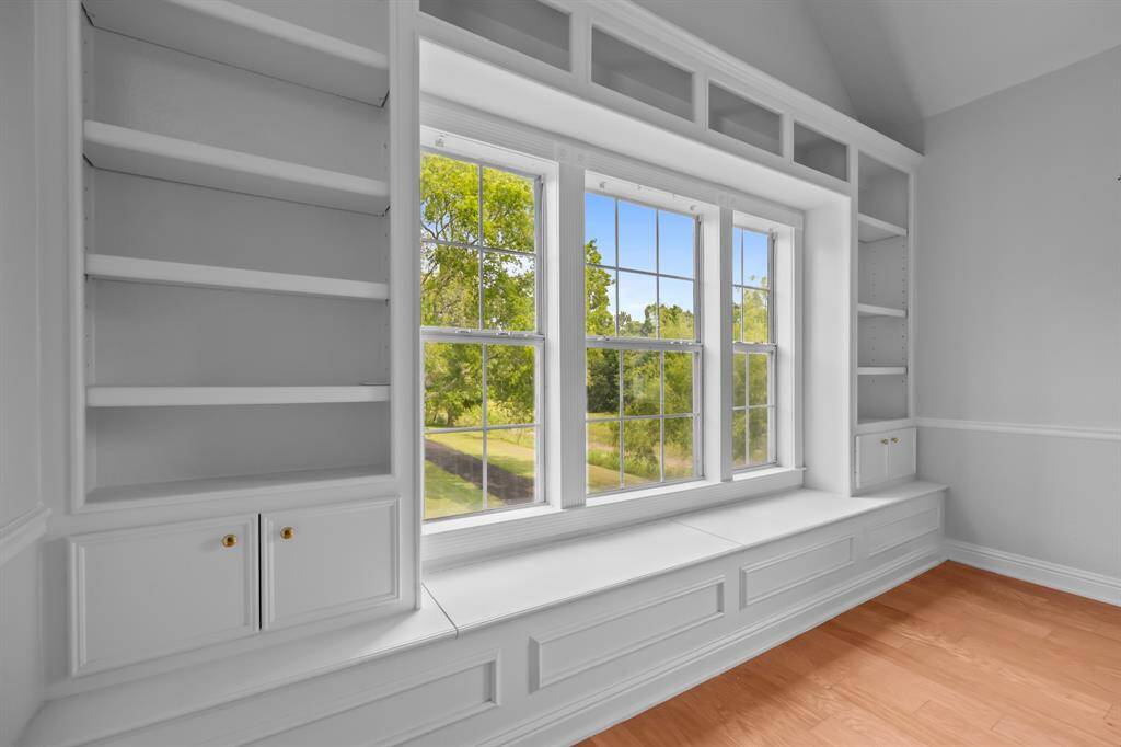 A charming built-in bonus awaits on the stair landing, featuring windows flanked by bookshelves, and cozy bench seating with hidden storage beneath.