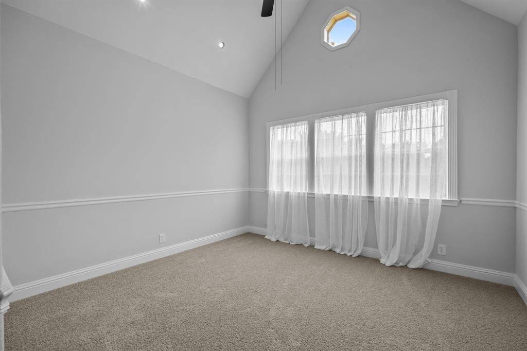 The secondary bedroom features vaulted ceilings and has been updated with fresh carpet, new paint, and an abundance of stunning natural light.