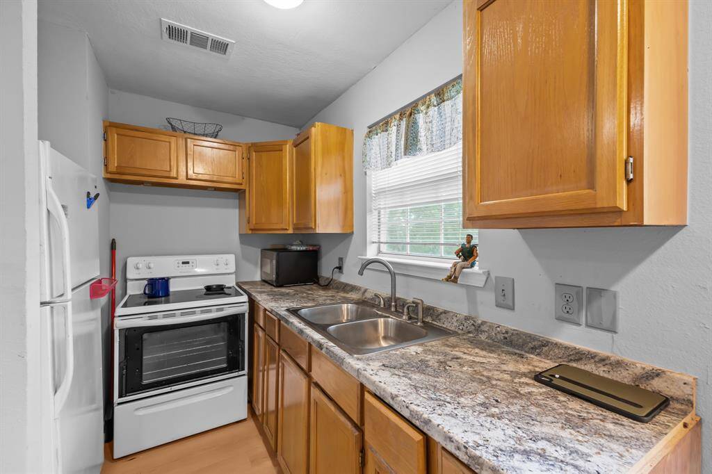 The full kitchen offers generous storage and prep space—compact yet fully equipped with everything you need. A window above the sink frames peaceful views, adding charm to everyday moments.