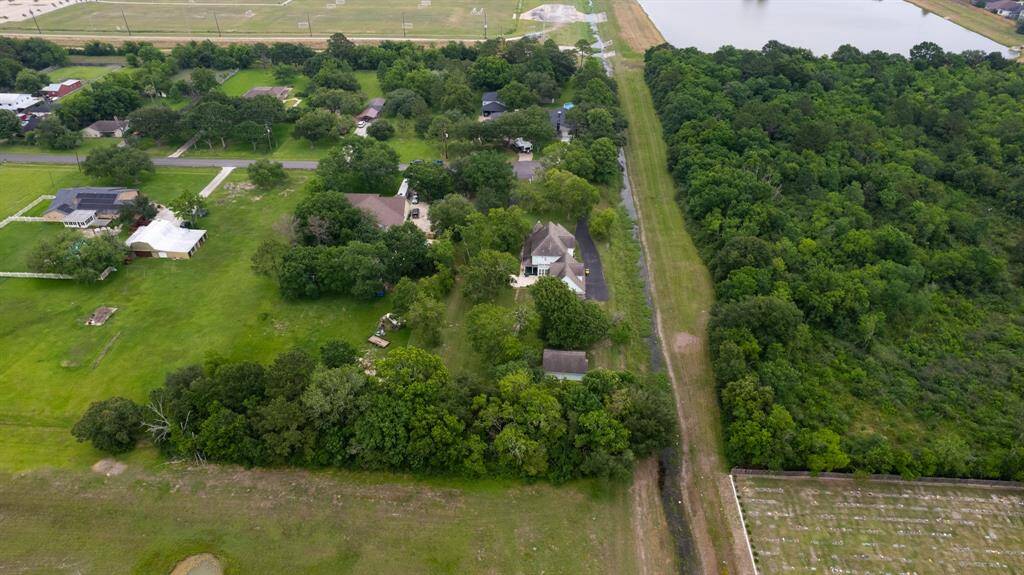 Breathtaking aerial views showcase the rare privilege of living tucked away in one of Pearland’s most established areas—surrounded by lush green space with no neighbors to the right or behind. Peace, privacy, and endless greenery await.