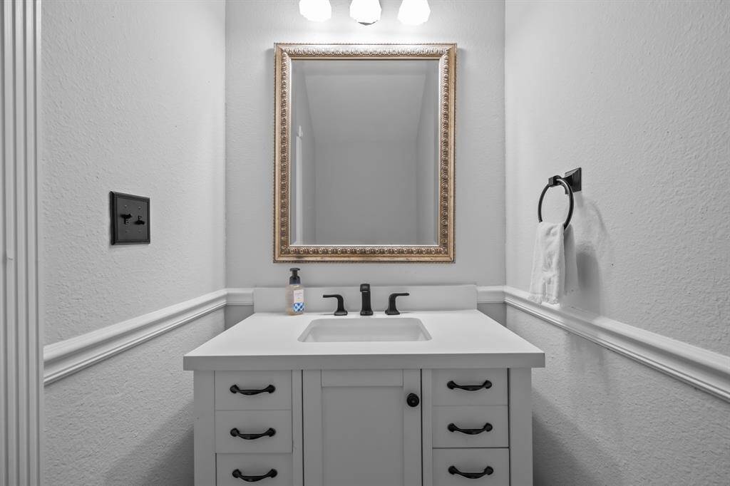 The half bath has been refreshed with a stylish new vanity, updated fixtures, and fresh paint for a clean, modern feel.