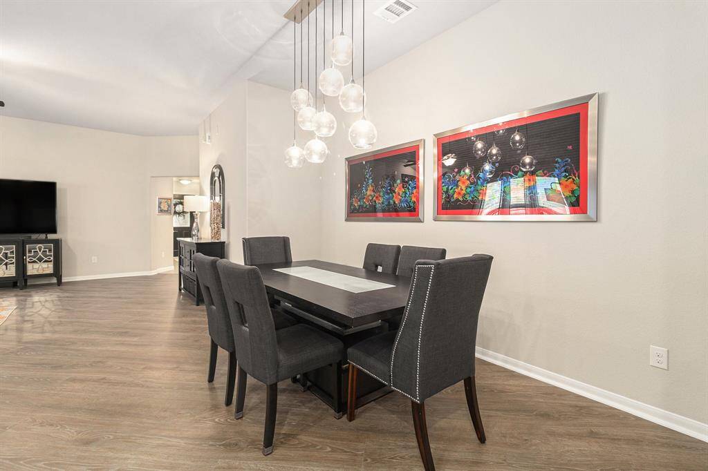 Dining area with modern lighting fixture creates a stylish and inviting space for all to gather.