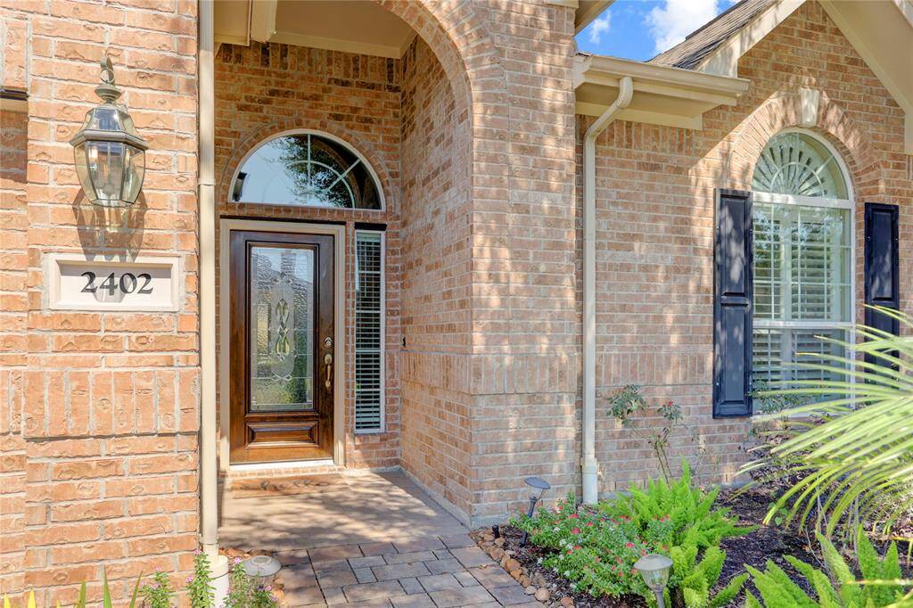 The front entry way features a decorative leaded glass door and arched transom window.