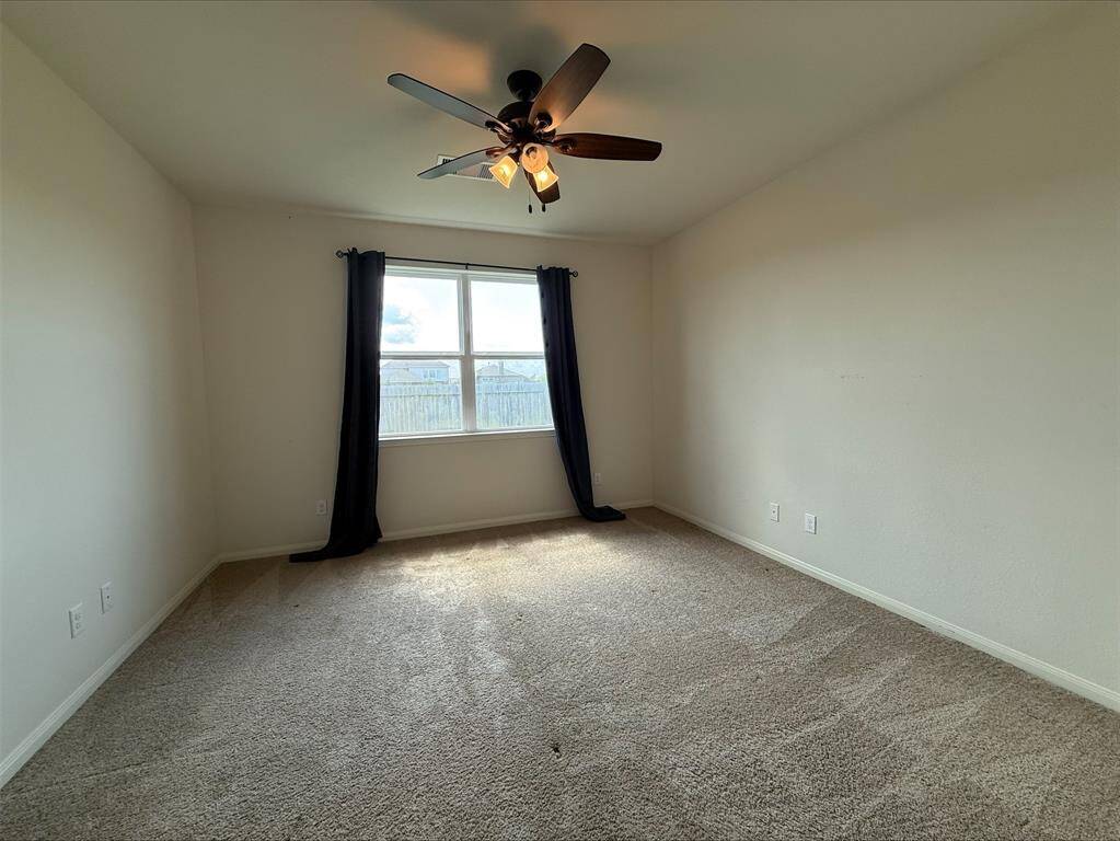 Primary Bedroom with carpet and ceiling fan.
