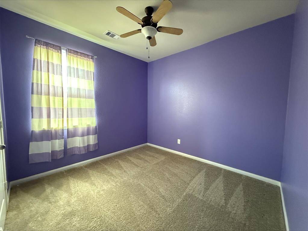Bedroom 2 of 3. All bedrooms have ceiling fans.
