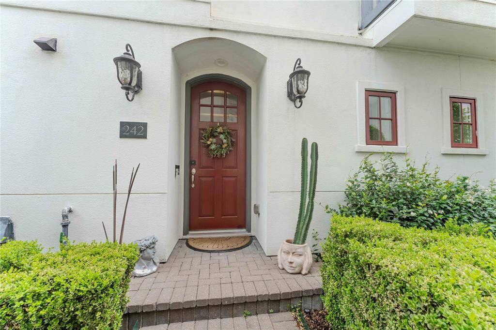 Charming front entry with a red door, giving it a welcoming and stylish appearance. Home is conveniently located and accessible with a private feel.