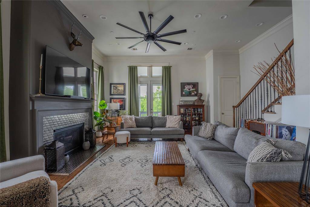 The perfect combination of class and cozy, this spacious living area is enhanced by tall ceilings, two balconies and a modern fireplace. Natural light pours in through tall windows, enhancing the room's airy feel.