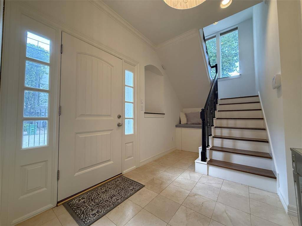 Alternate view of the entry foyer. Natural light flows in from the tall windows above the stairway landing to the 2nd floor.