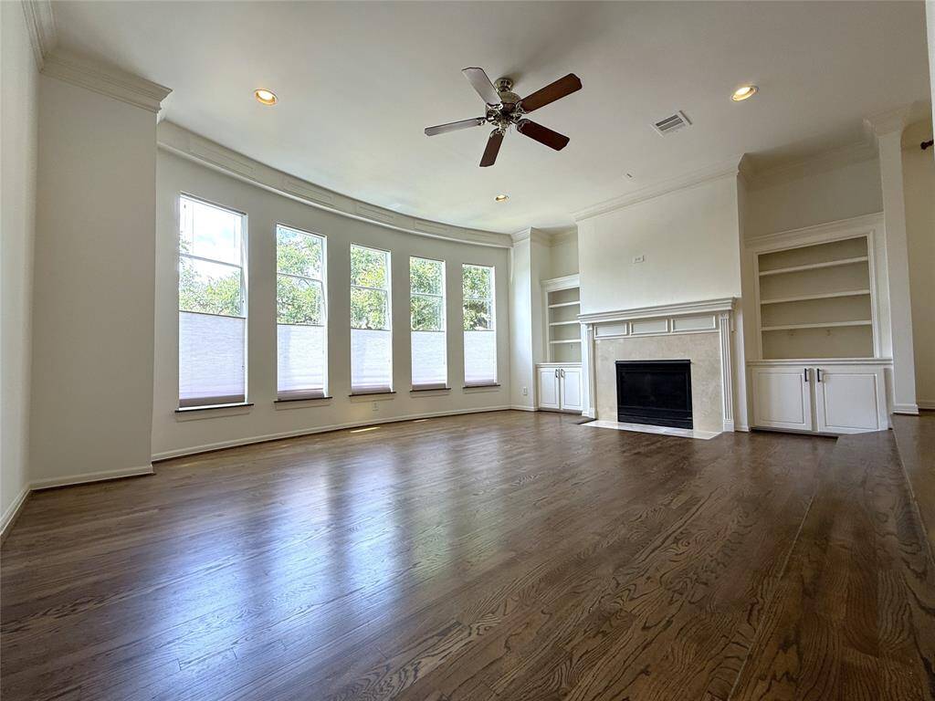 The spacious living room offers built-in cabinets/shelving on either side of the gas fireplace.