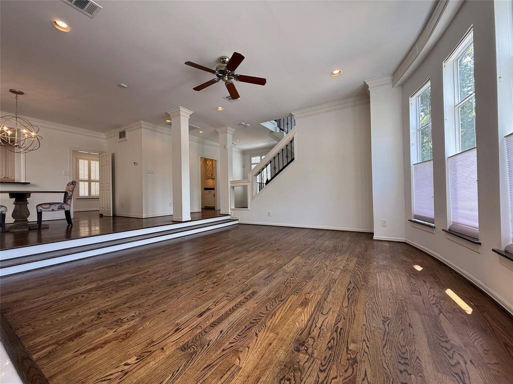 Alternate view of the sunken living room with high ceiling, ceiling fan, recessed lighting & crown molding.