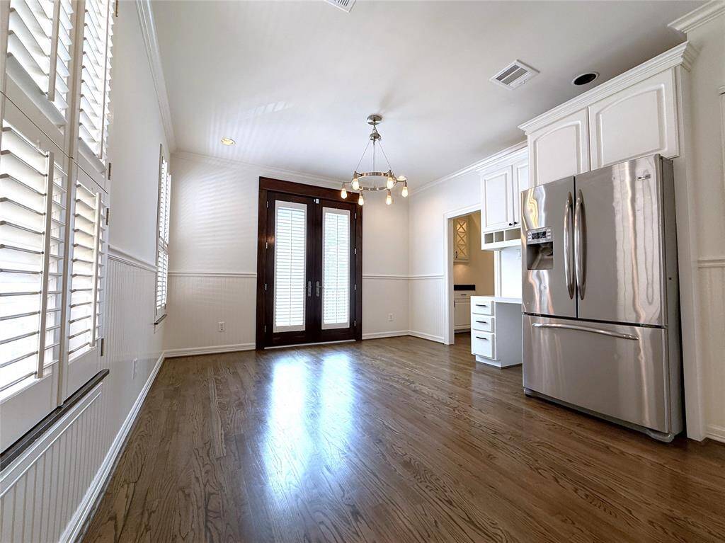 Adjoining the kitchen, the breakfast room offers a built-in desk. French doors open in from a Juliet balcony.