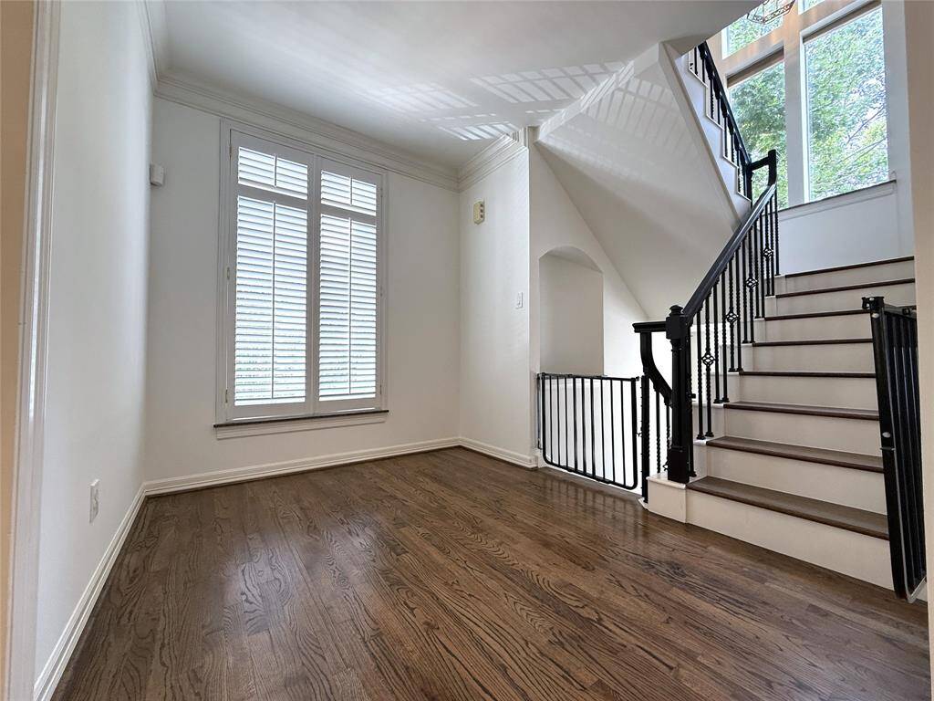 Just past the wet bar & 1/2 bath, another view of the 2nd floor bonus space. From tall windows, natural light flows into the stairway landing.