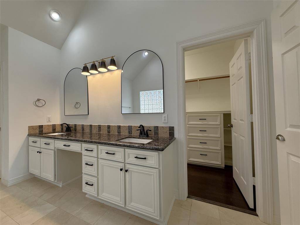 To the right of the vanity, the door opens into the 1st walk-in closet.