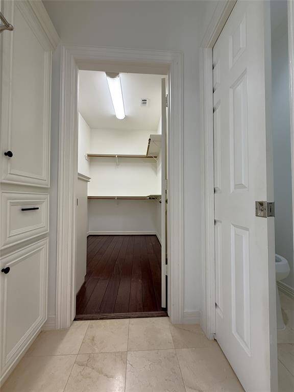 Just before the 2nd walk-in closet, on the right, a pocket door opens to the water closet. On the left is linen storage & a built-in hamper.