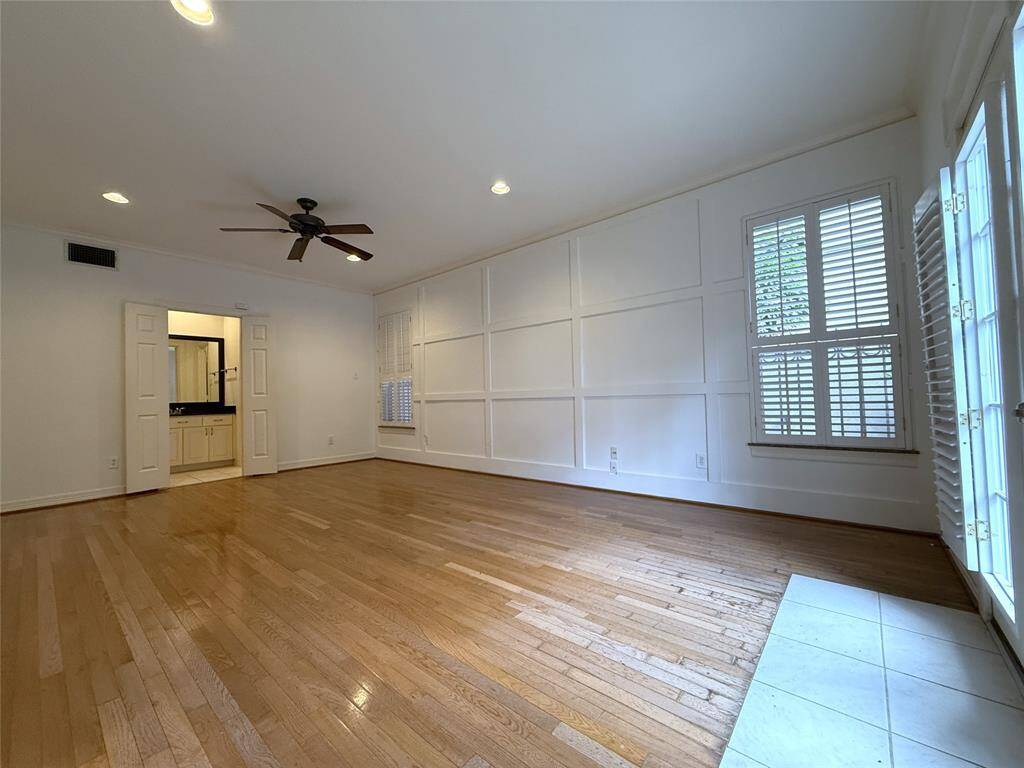 The 1st floor bedroom, with ceiling fan, recessed lighting & plantation shutters, and en-suite bath is spacious.